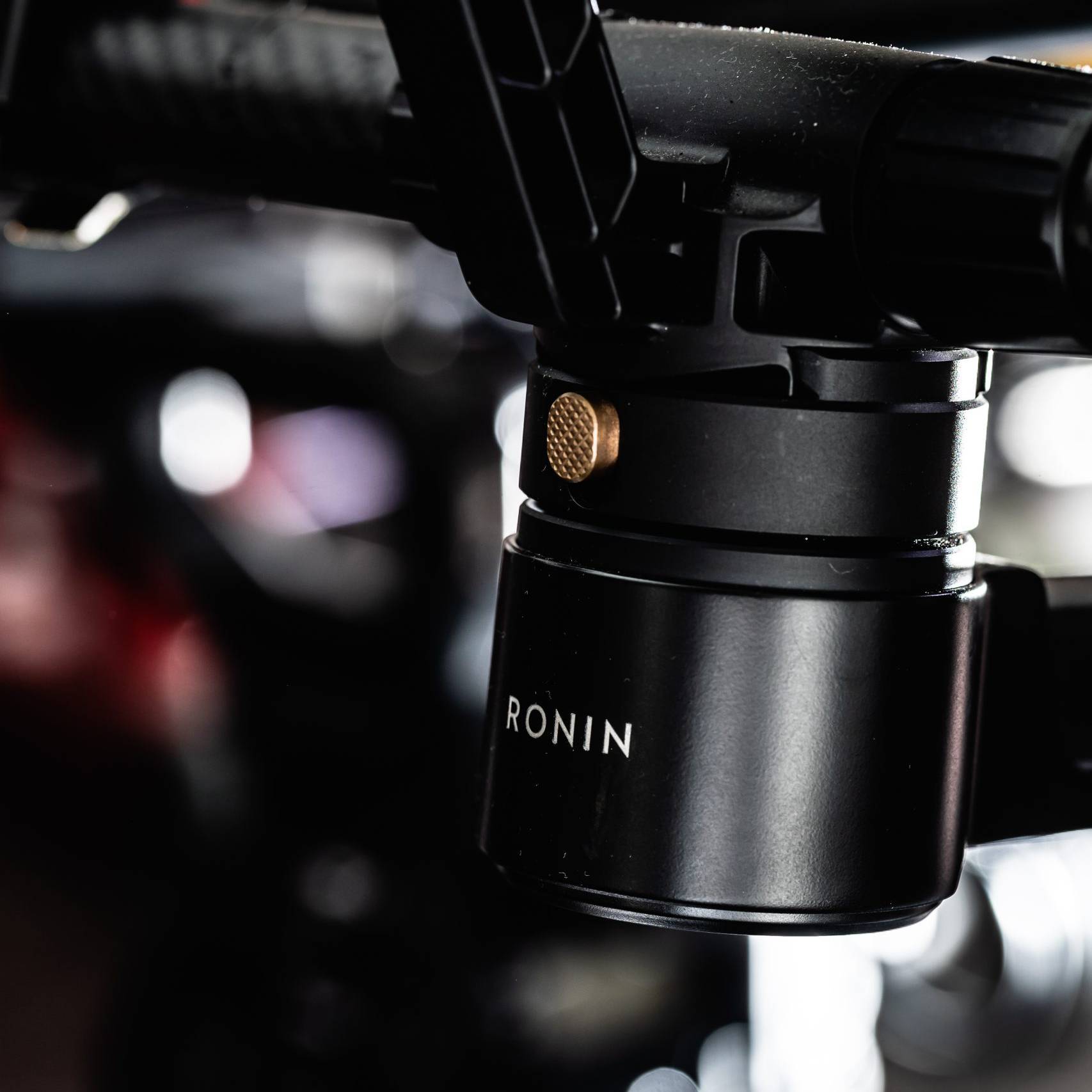 画像: 黒いカメラスタビライザーのクローズアップ画像。ローニン（Ronin）ブランド名が示されており、安定した映像撮影に最適な機材です。写真撮